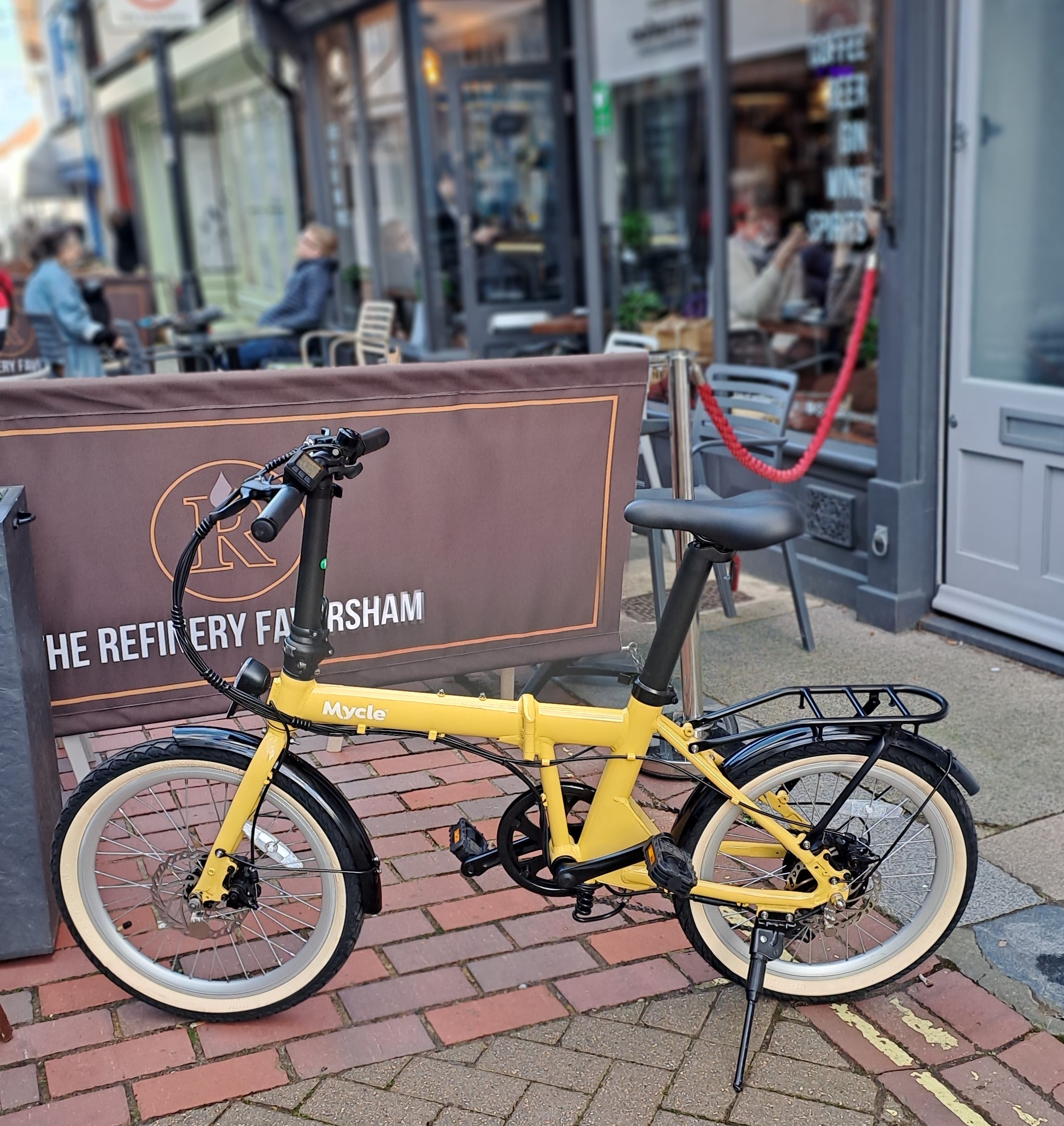 The Mycle meaty folding e-bike outsdie a cafe.
