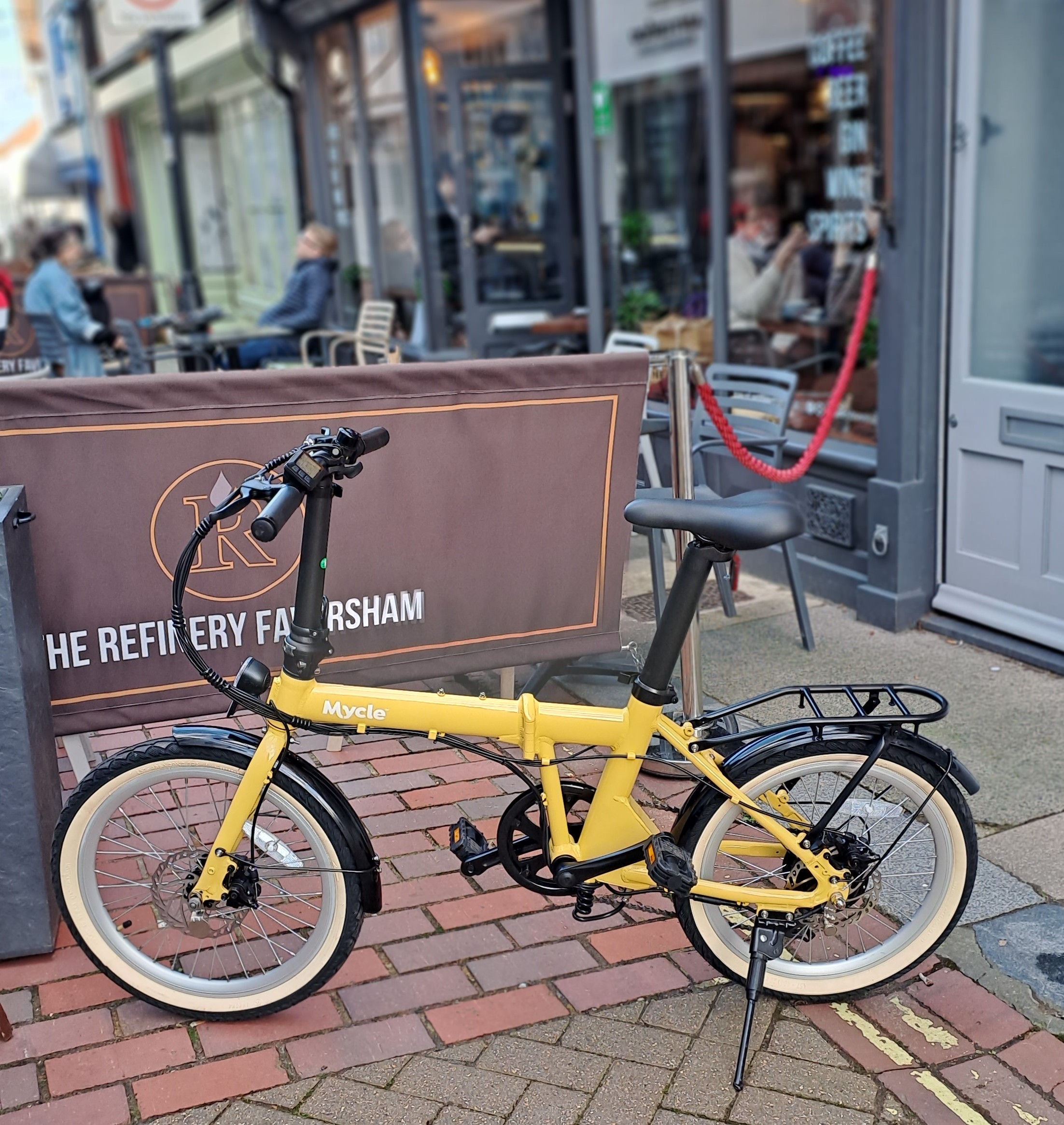 The Mycle meaty folding e-bike outsdie a cafe. 